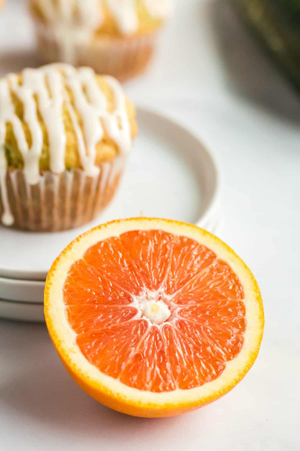 Cara cara orange sliced in half with zucchini muffin in background.