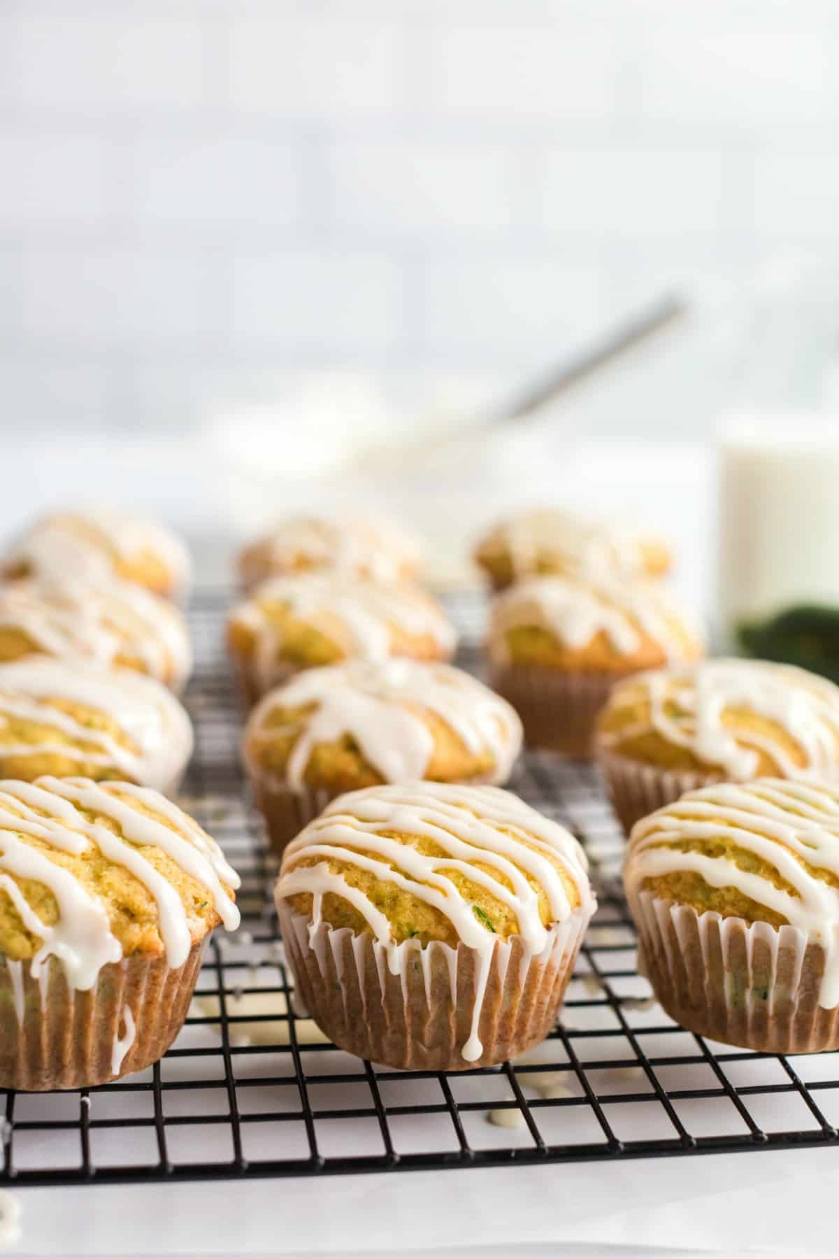 Zucchini orange muffins on a wire rack with orange glaze drizzled on top.