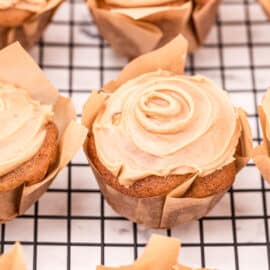 Apple muffins topped with a swirl of caramel glaze.