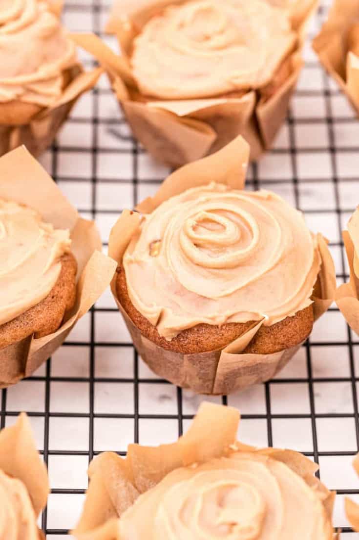 Apple muffins topped with a swirl of caramel glaze.