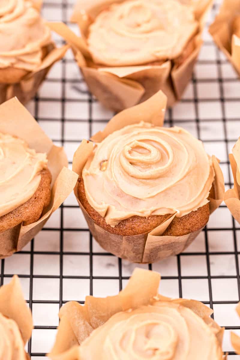 Apple muffins topped with a swirl of caramel glaze.