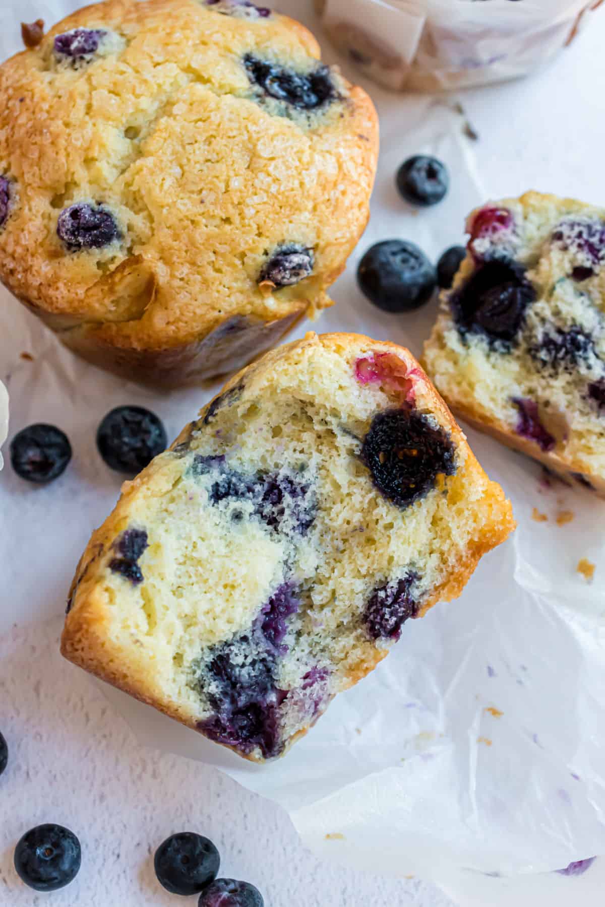 Bueberry muffin cut in half to reveal tender crumb and fresh berries.