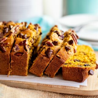 Sliced loaf of chocolate chip pumpkin bread on a cutting board.