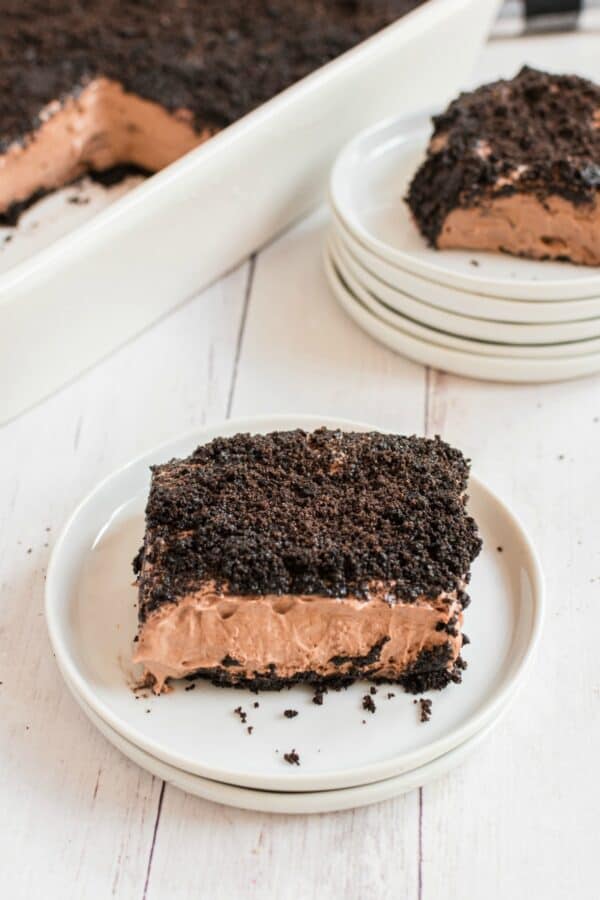 Slice of chocolate dirt pudding cake on a white plate.