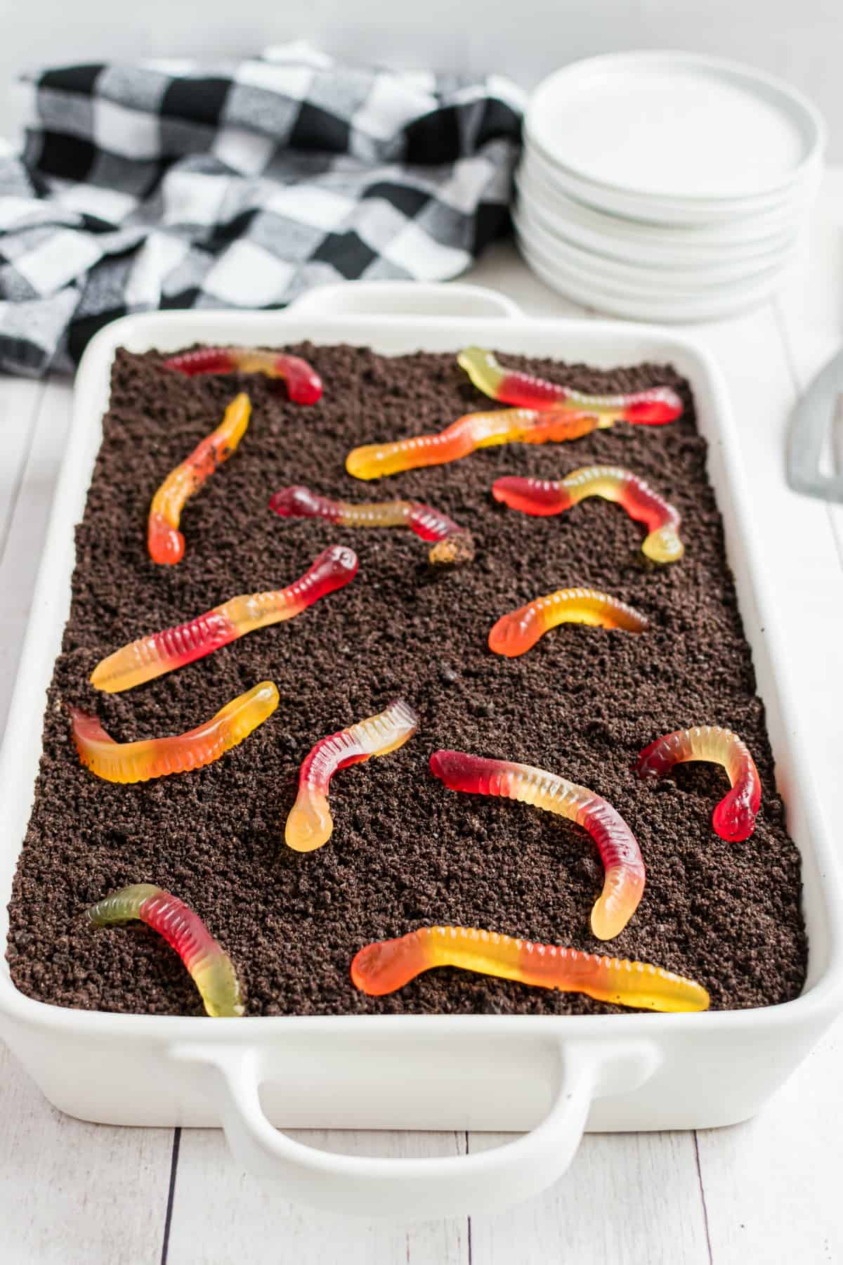 Dirt cake with gummi worms in a 13x9 white baking dish.