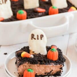 Slice of dirt cake with oreos and topped with a graveyard theme.