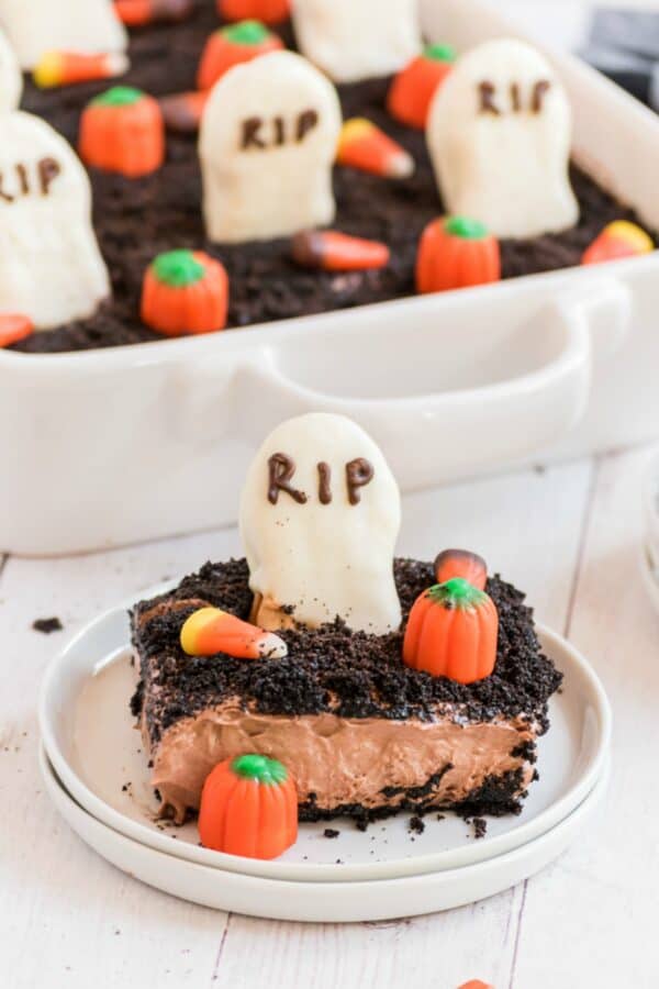 Slice of dirt cake with oreos and topped with a graveyard theme.