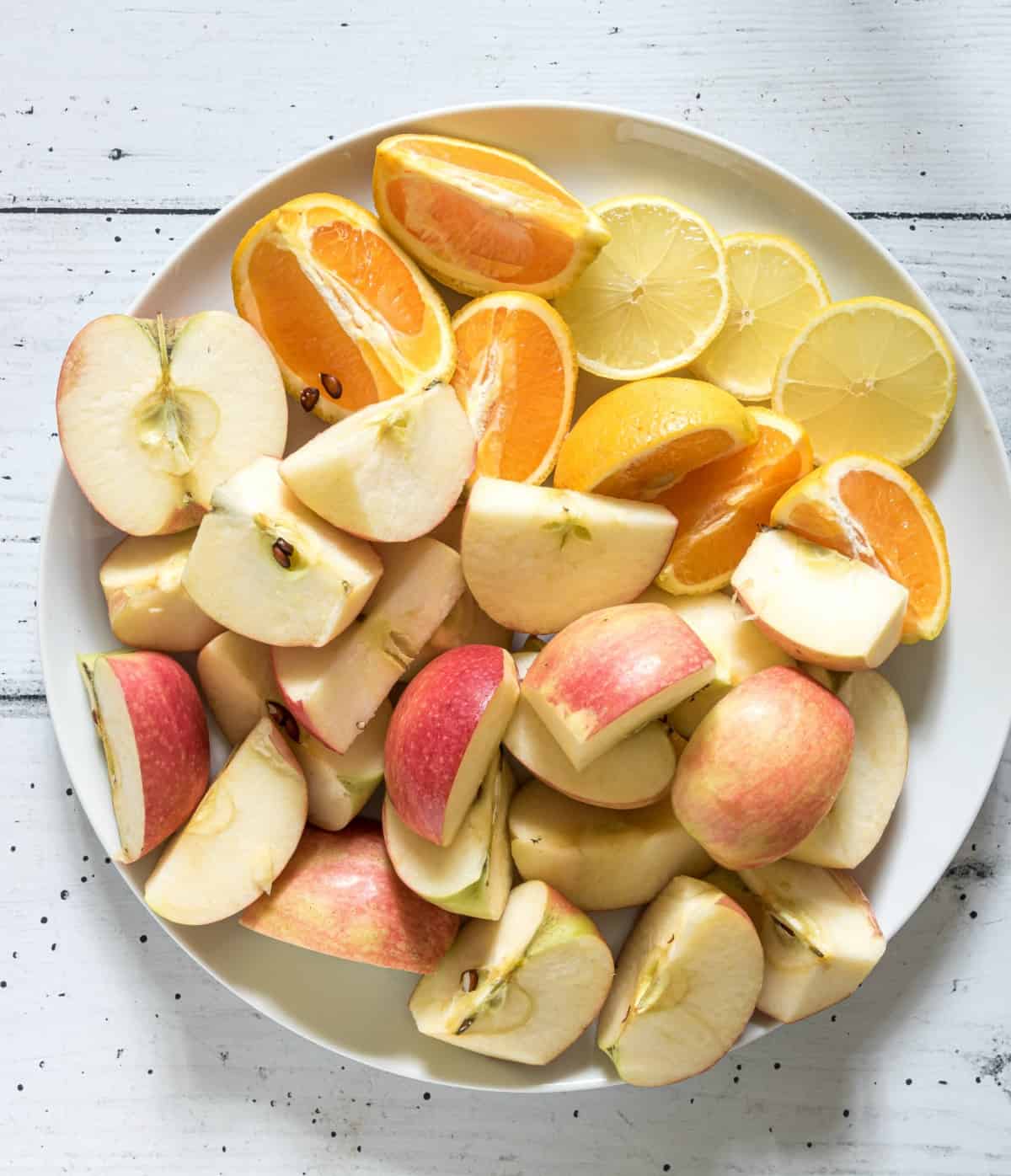 Apples, lemons, and oranges chopped for apple cider.