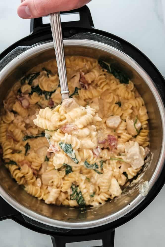Crack chicken pasta being ladled out of a pressure cooker.