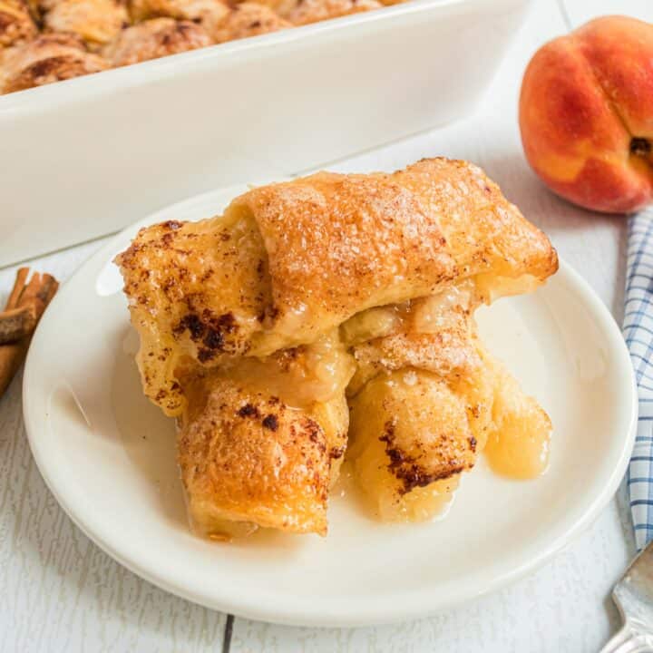 Peach dumplings on a white plate.