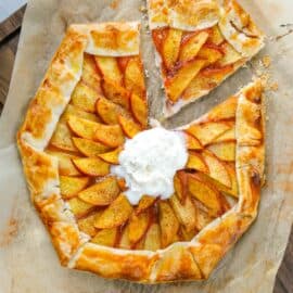 Peach galette with one slice cut and topped with ice cream.