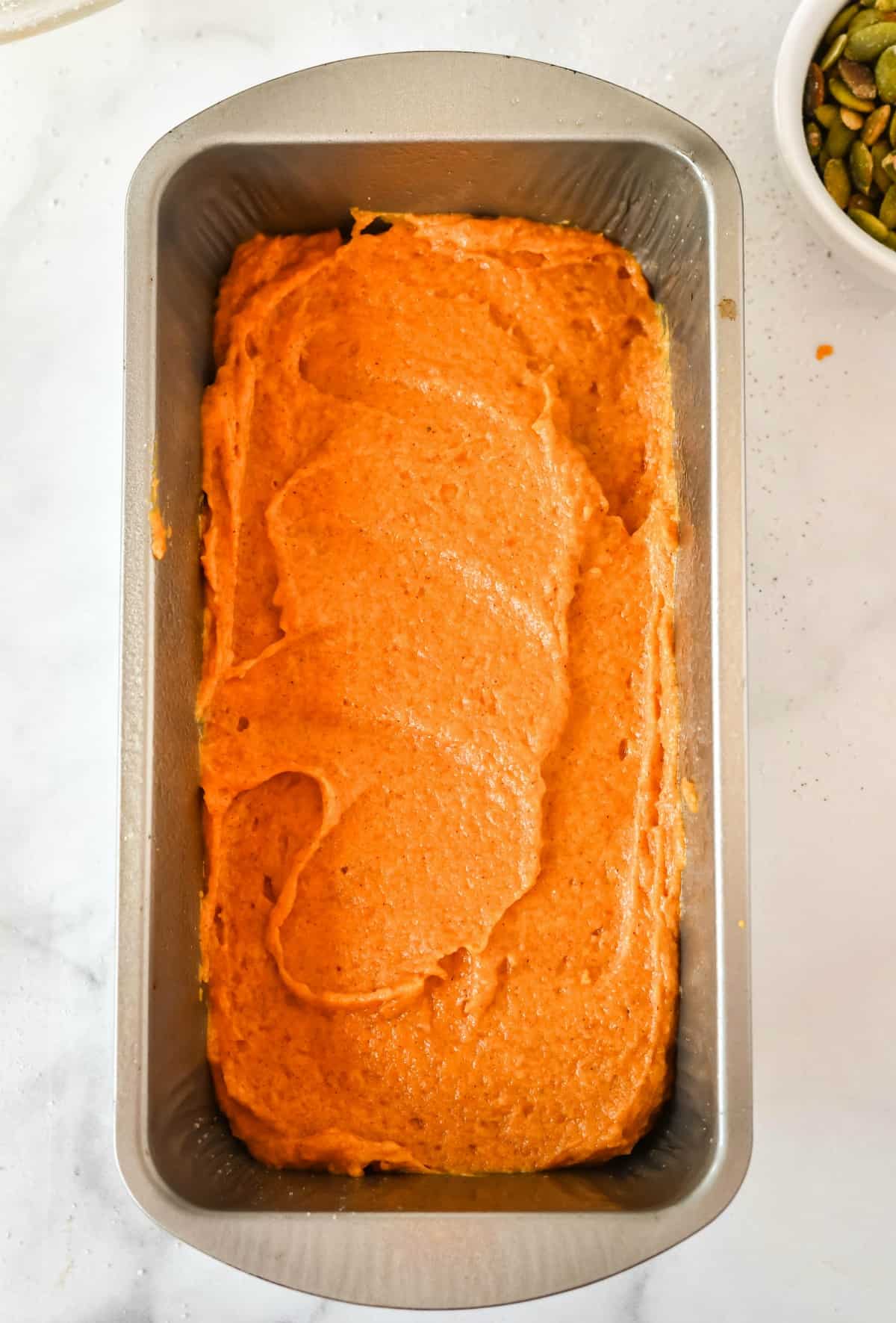 Pumpkin bread batter in a loaf pan before baking.