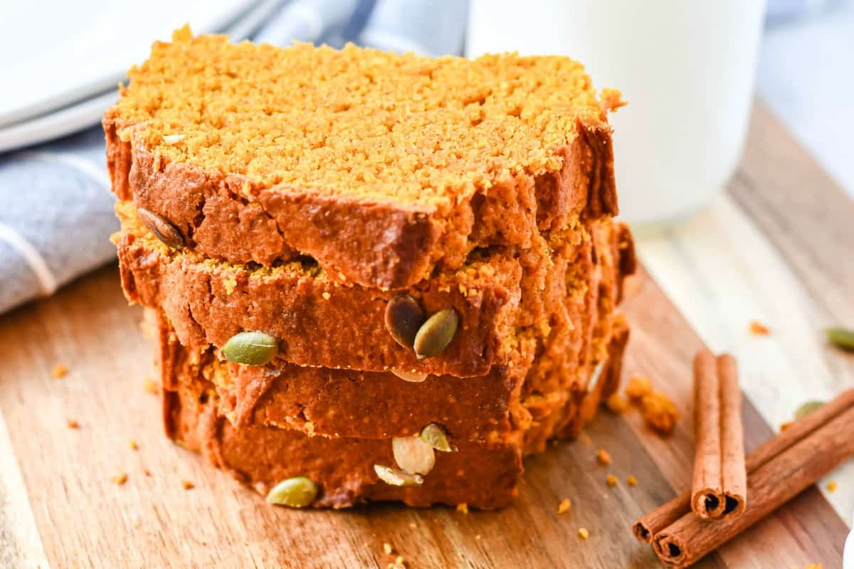 Slices of pumpkin bread on a wooden cutting board.