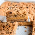 The most delicious layered cookie bars you'll eat this year! Graham cracker crust topped with a creamy pumpkin cheesecake and chocolate chip cookie dough. Baked to perfection, these Pumpkin Chocolate Chip Cheesecake Bars NEED to be on your dessert table.