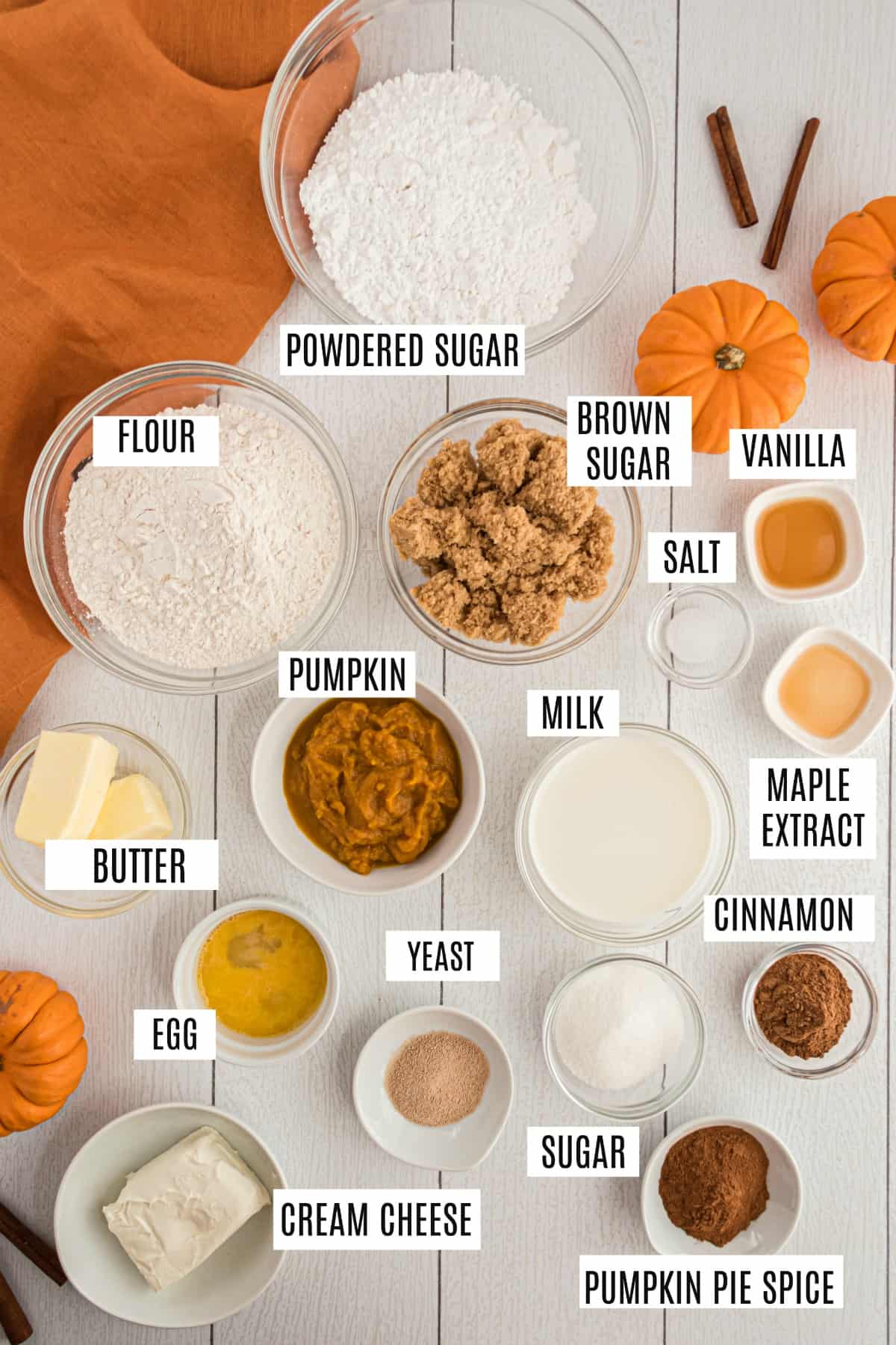 Ingredients needed to make pumpkin cinnamon rolls including yeast, pumpkin puree, and cinnamon.