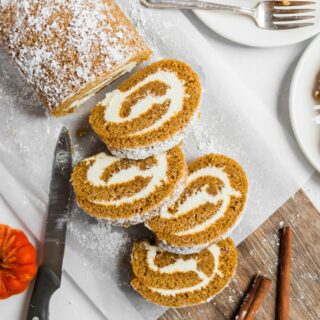 Sliced pumpkin roll with cream cheese frosting filling.
