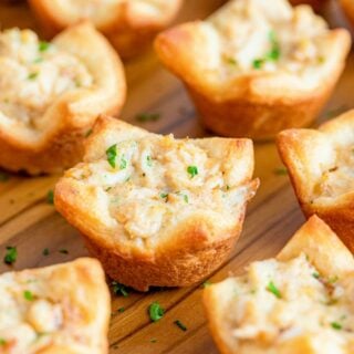 Baked crab puffs on a wooden tray.