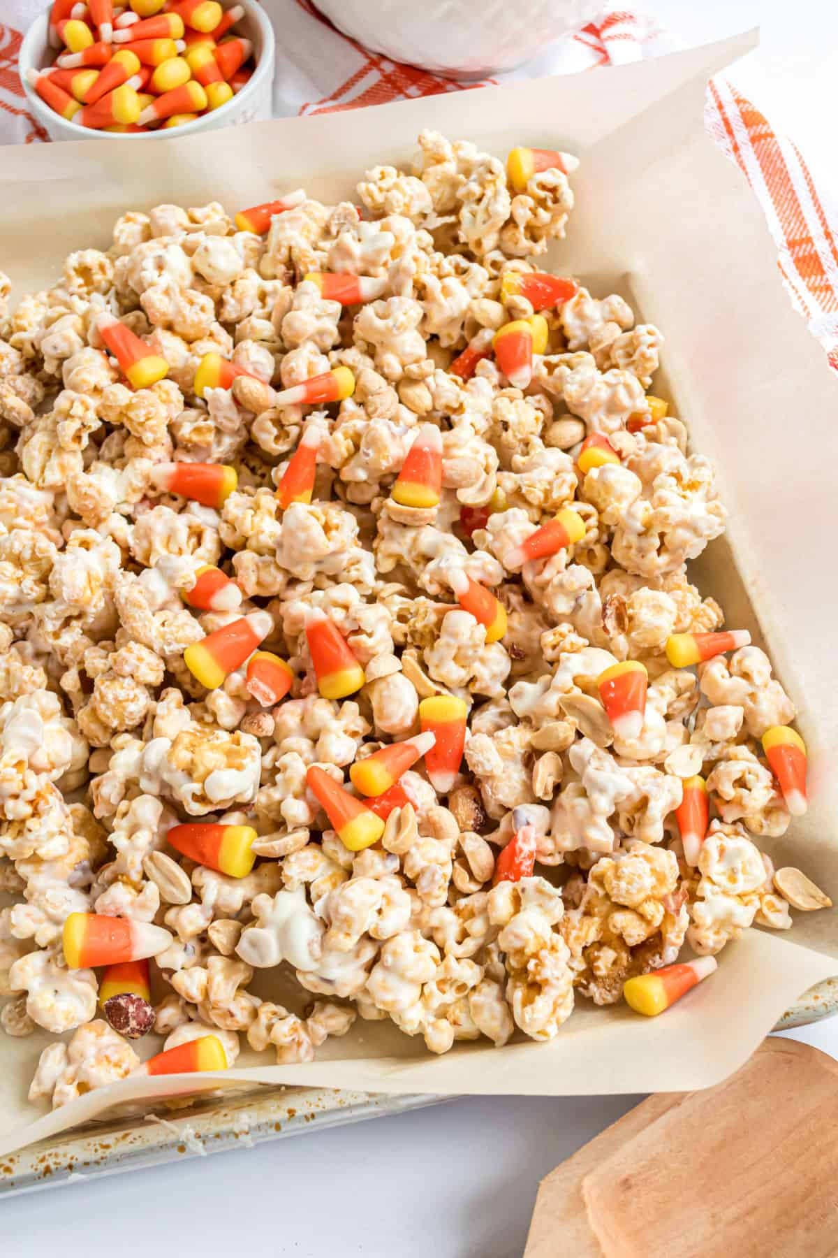 Homemade halloween caramel corn on a parchment paper lined cookie sheet.