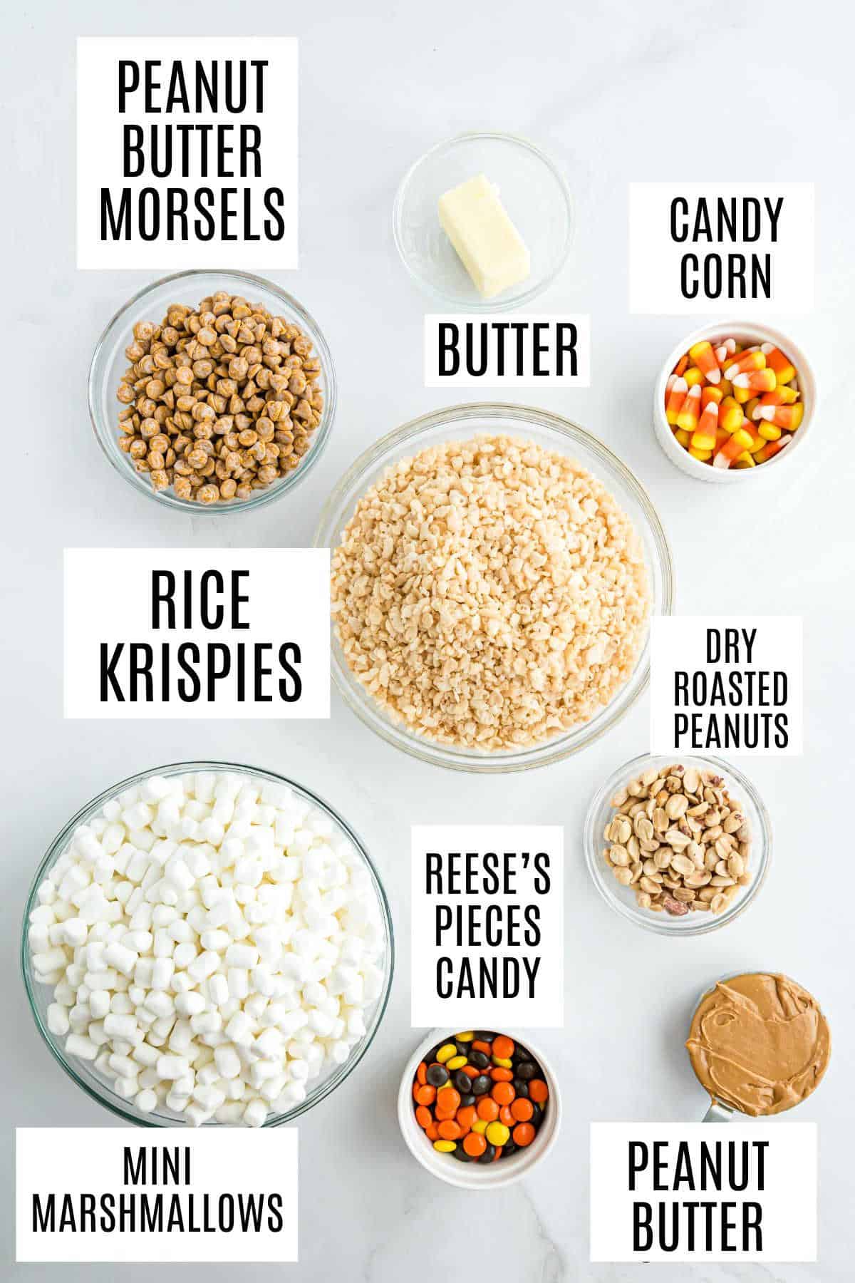 Various bowls with labeled ingredients: peanut butter, marshmallows, rice krispies, peanuts, candies, butter—perfect for making peanut butter candy corn krispie treats.