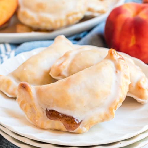 Dessert is ready in 30 minutes with these Glazed Peach Hand Pies! The flaky crust and spicy cinnamon filling are the perfect combo in a hand pie, plus they're baked not fried!