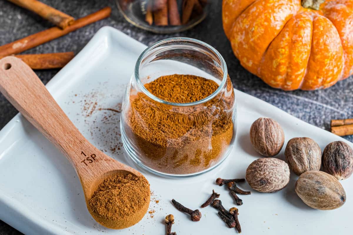 Teaspoon of pumpkin pie spice removed from jar of homemade spice substitute.