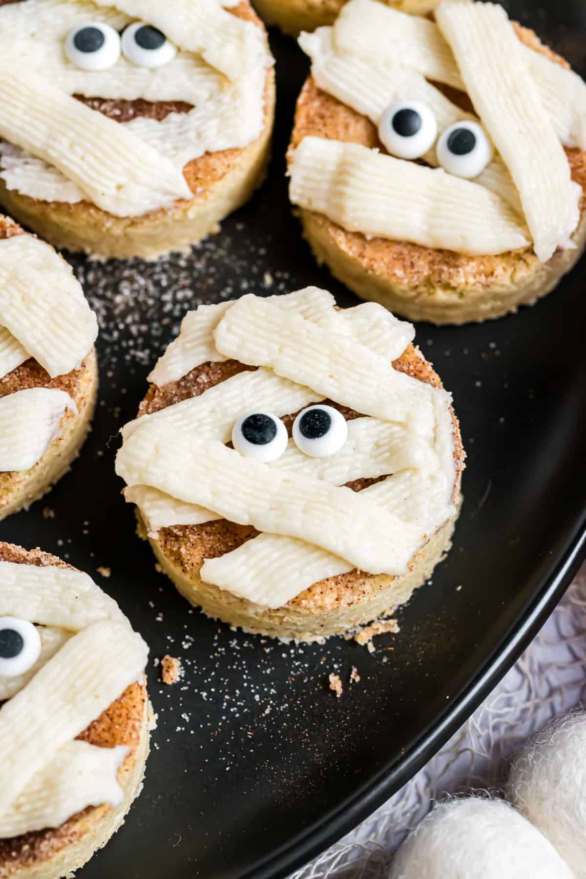 Mummy snickerdoodles on a black plate.