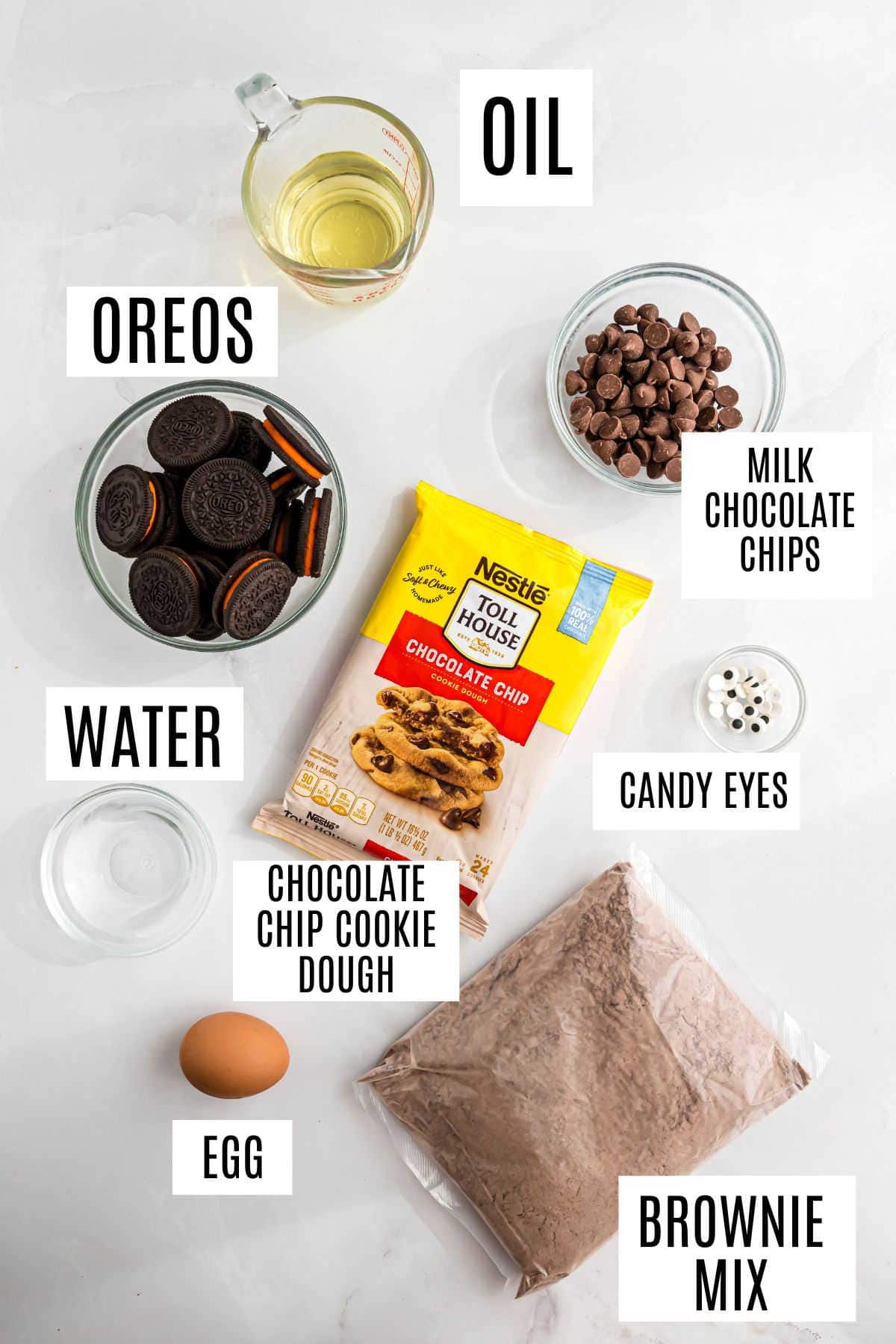 Baking ingredients labeled: Oreos, oil, water, chocolate chips, candy eyes, egg, dough, and brownie mix—everything you need for spooky brookies!.