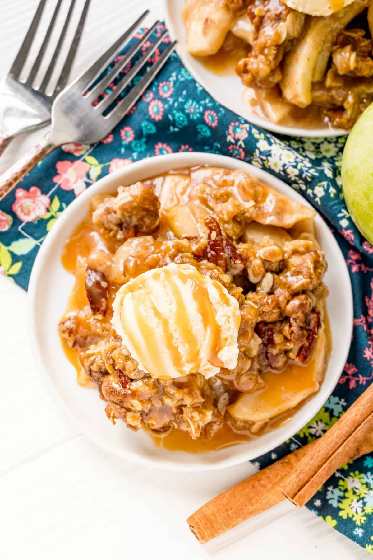 Overhead view of apple crisp on a plate with ice cream.