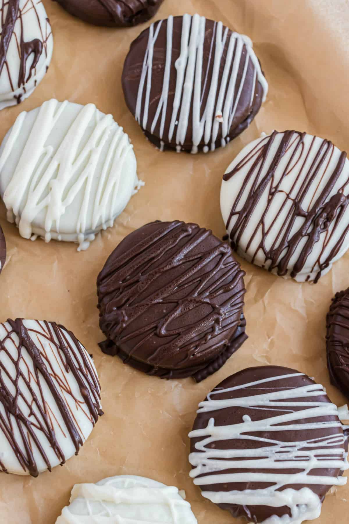 Chocolate and white chocolate covered oreos on parchment paper.