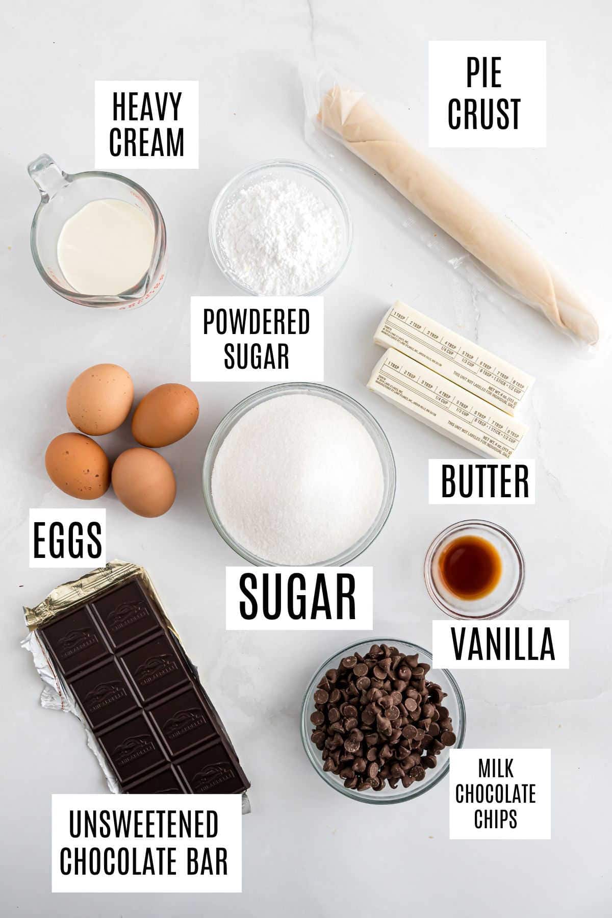 Baking ingredients on a white surface: eggs, sugar, butter, milk, chocolate, vanilla, pie crust, and powdered sugar—everything you need to create a decadent French silk pie.