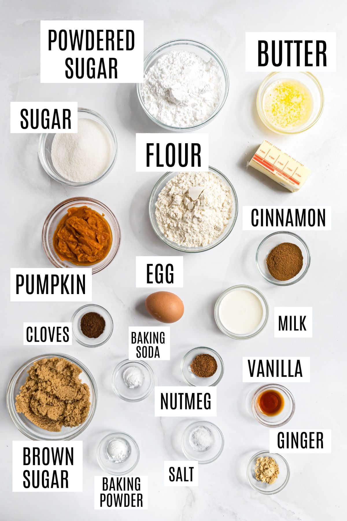Pumpkin cookie ingredients in bowls, labeled: flour, sugars, spices, butter, egg, pumpkin, milk, baking soda, and powder—perfect for making pumpkin streusel donuts or cozy autumn treats.