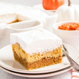 Slice of pumpkin magic on a stack of white dessert plates.