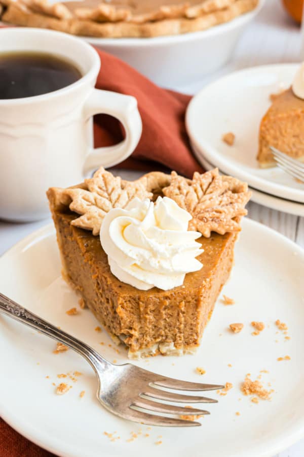 Slice of pumpkin pie with a bite taken out.