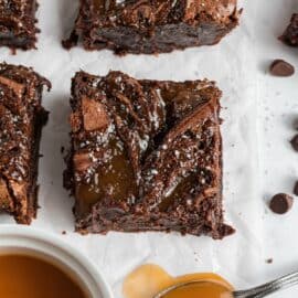 Brownies cut in large squares with caramel sauce.