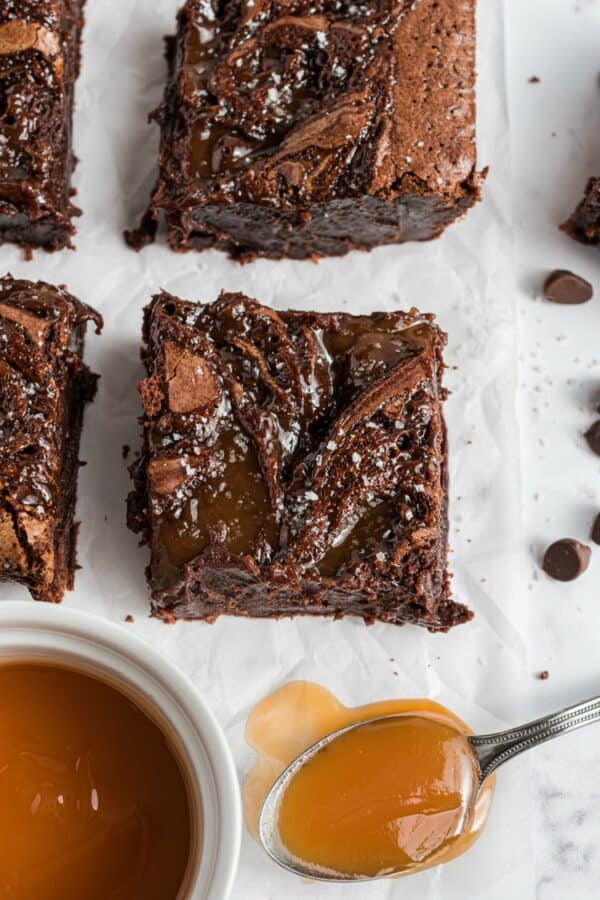 Brownies cut in large squares with caramel sauce.