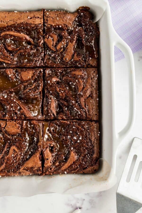 Caramel swirled brownies in a white baking dish.