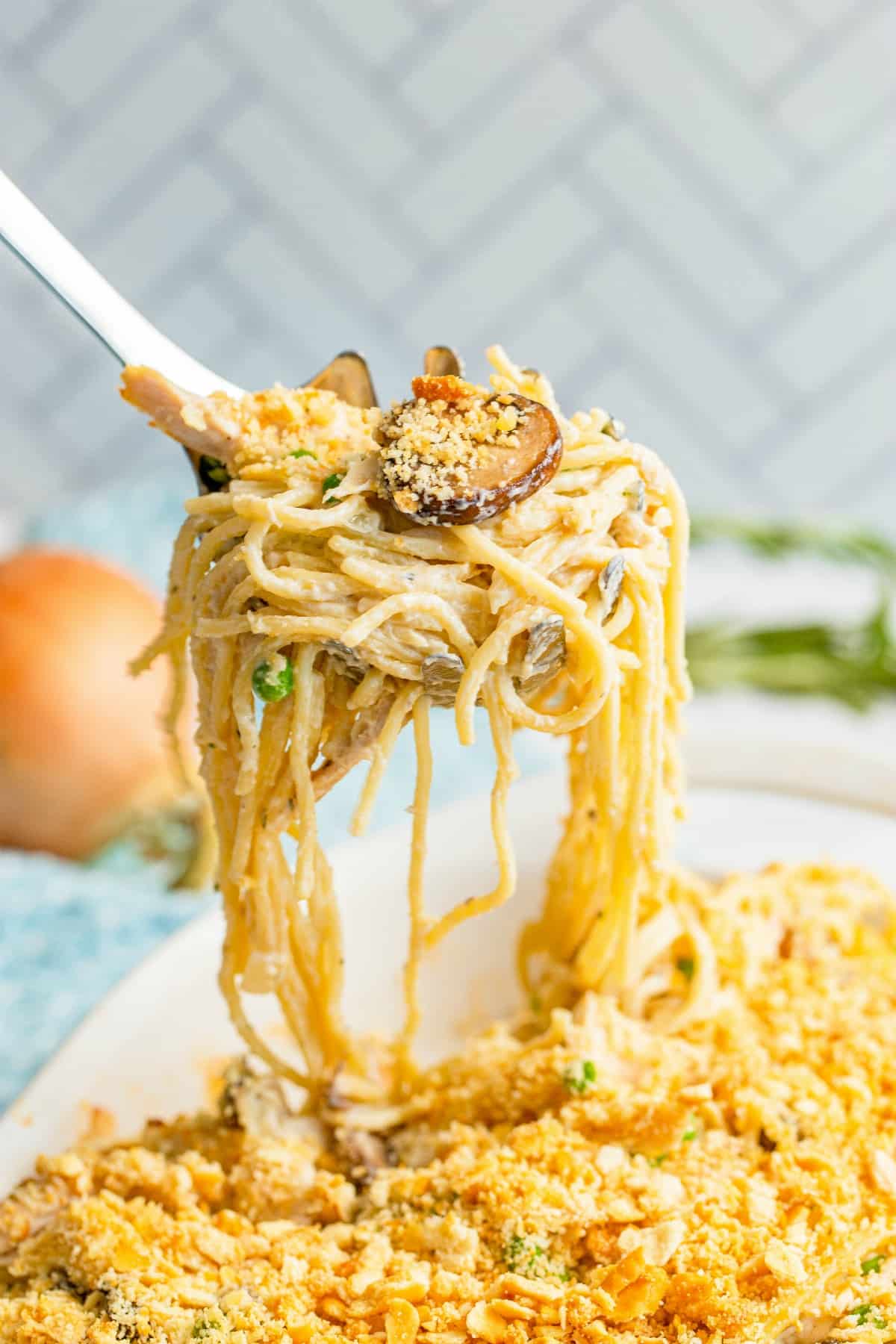 Scoop of turkey tetrazzini lifting out of baking dish.