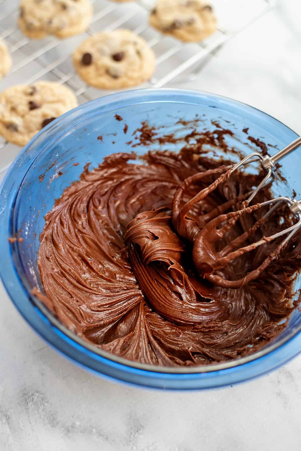 Chocolate frosting in a blue bowl.