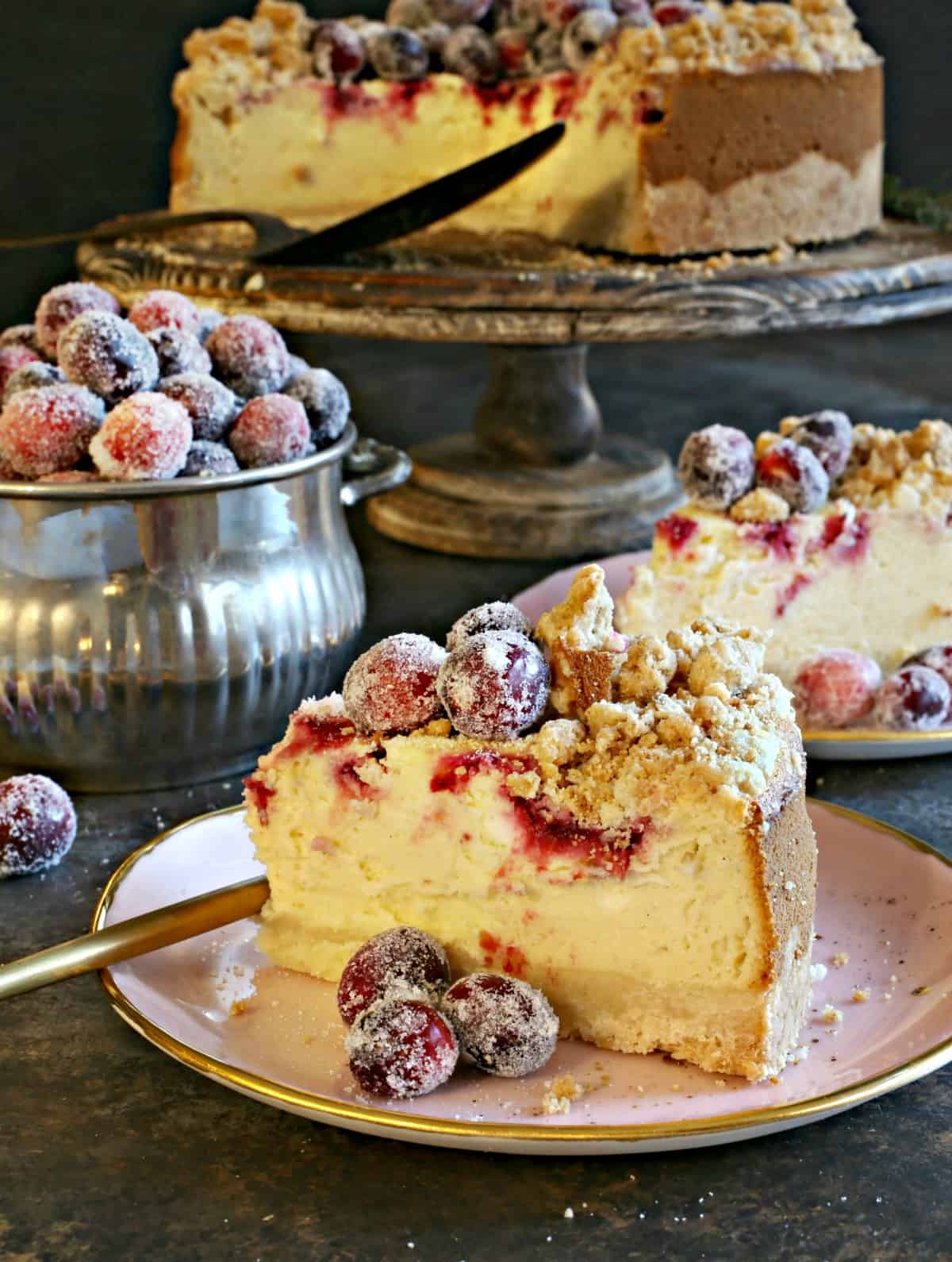 Slice of cranberry cheesecake with sugared cranberries.