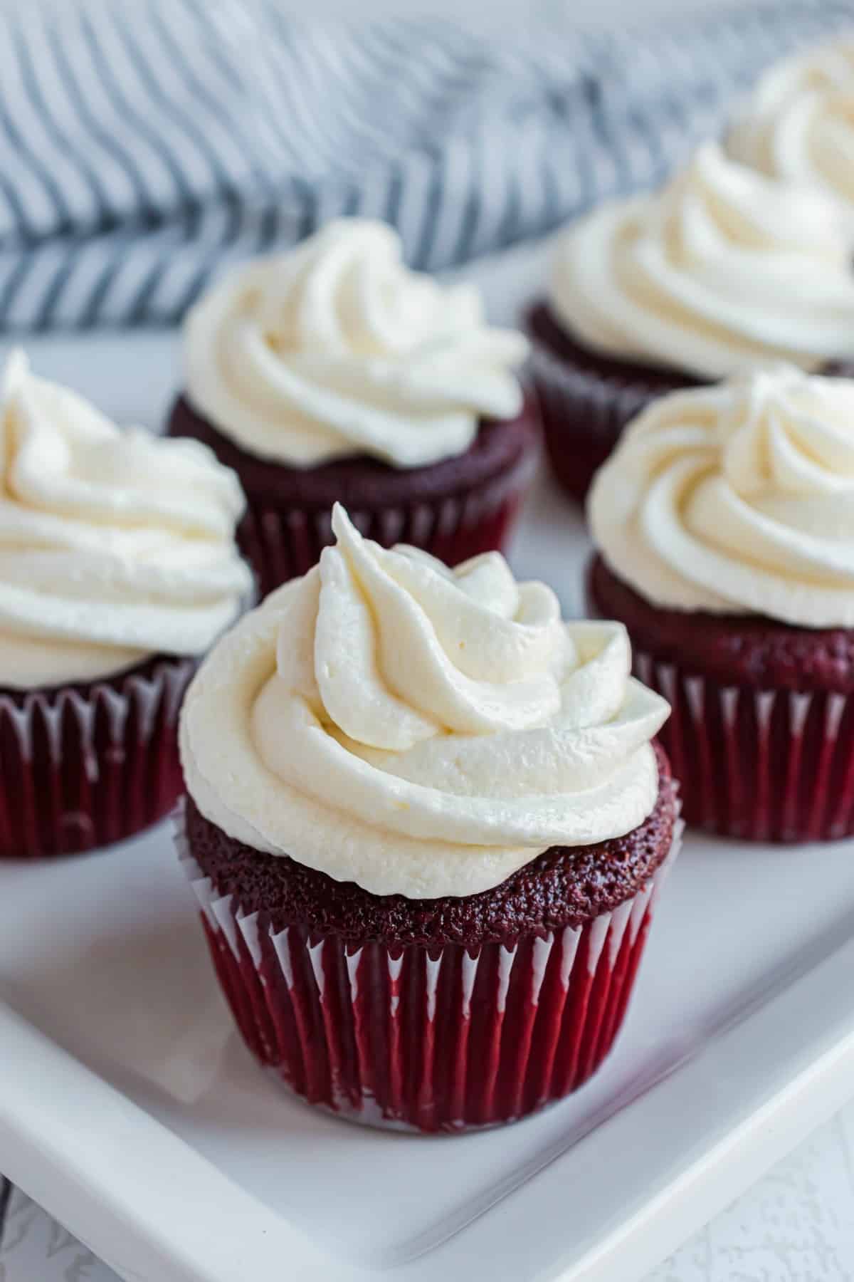 Cream cheese frosting on red velvet cupcakes.