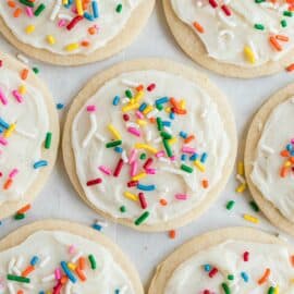 Sugar cookie frosting on circle cookies with festive sprinkles.