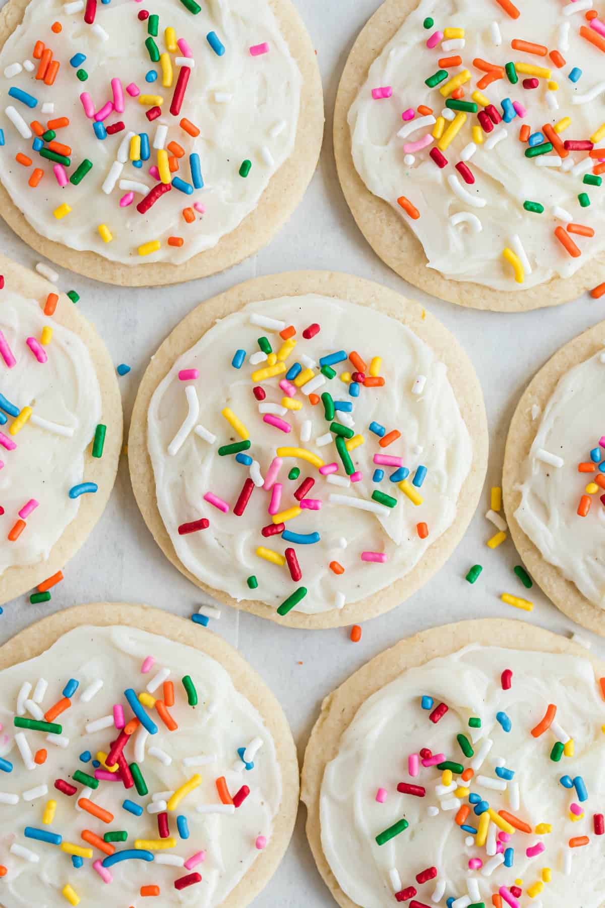 Sugar cookie frosting on circle cookies with festive sprinkles.