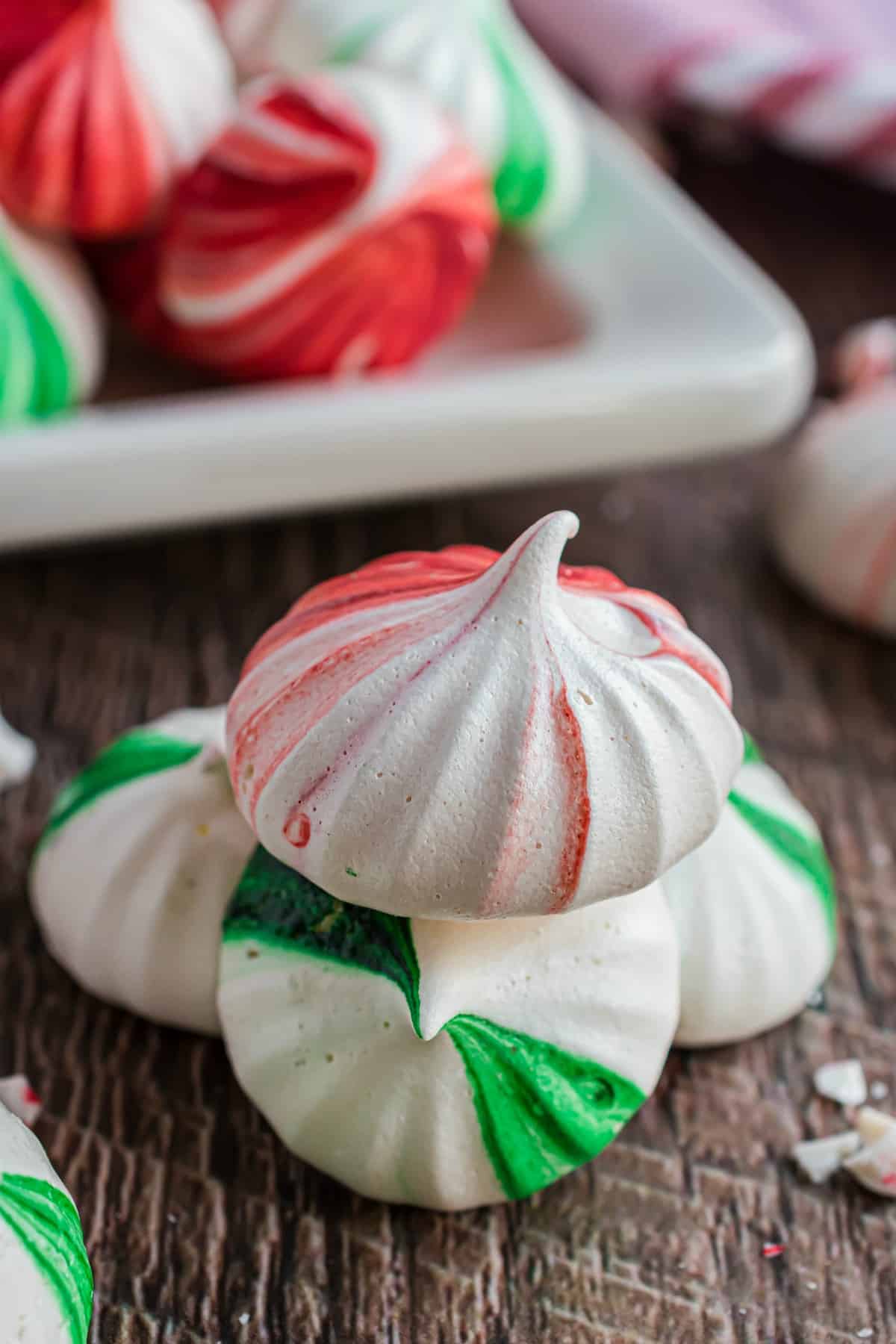 Stack of three meringue cookies with red and green.