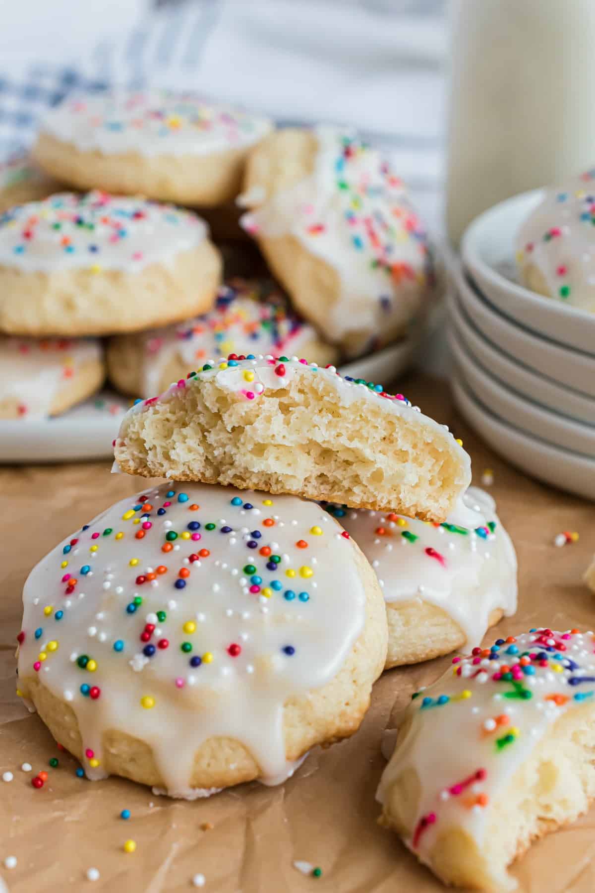 Ricotta cookies on wooden board with one cut in half.