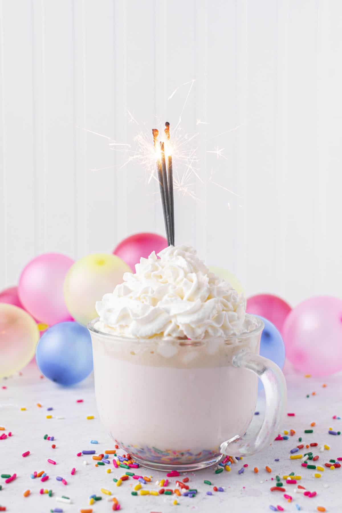 Mug of hot cocoa with whipped cream and sprinkles.