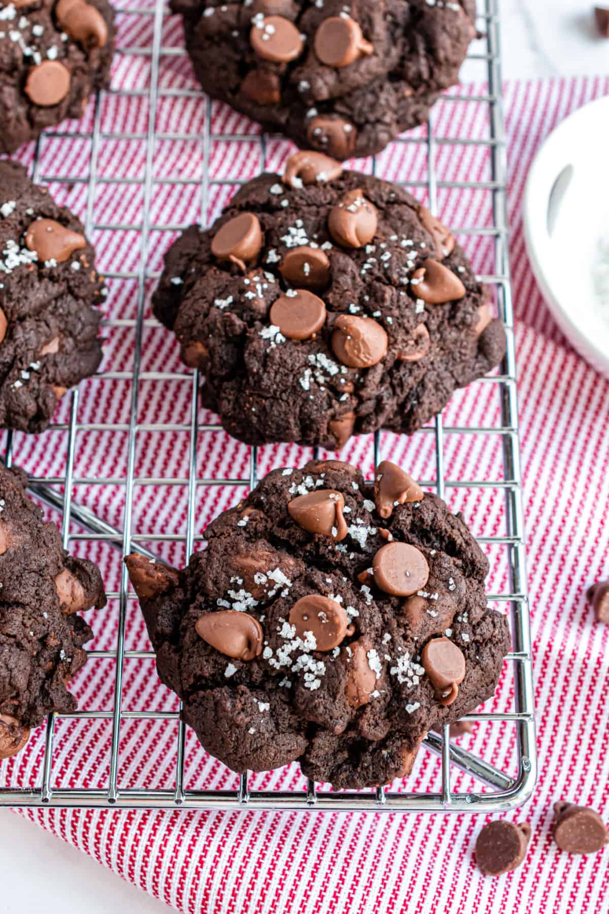 Chocolate cookies on a wire cooling rack with pink linen.