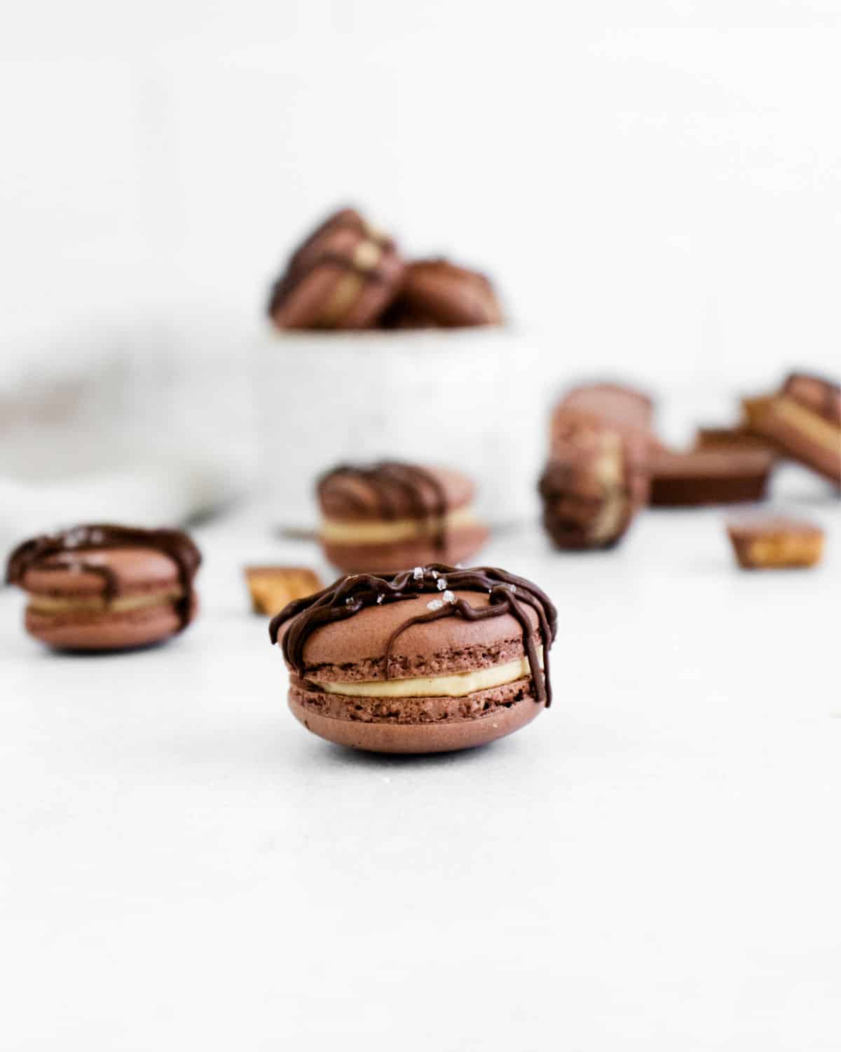 Chocolate macarons with peanut butter filling and chocolate drizzle.