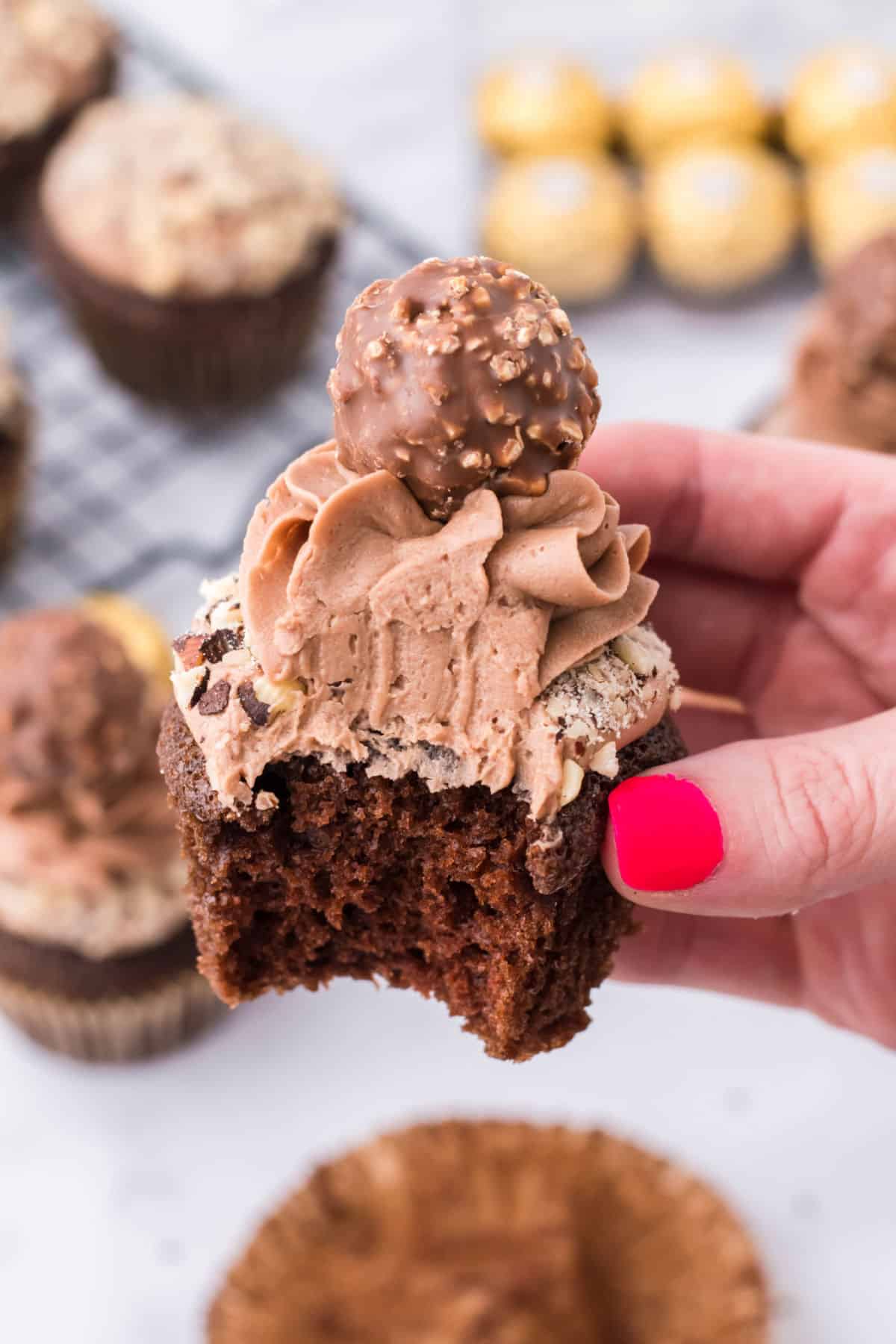 Chocolate hazelnut cupcake with one bite removed.