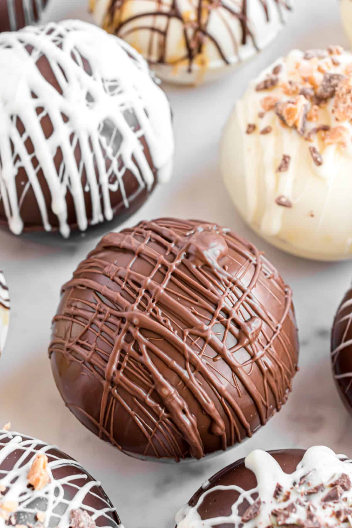 Hot chocolate cocoa bombs on a parchment paper baking sheet ready to use.