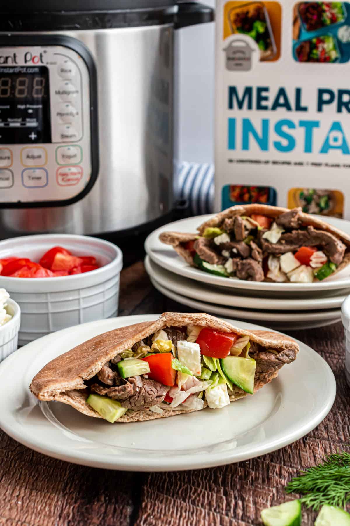 Beef gyros in a pita with vegetables and feta cheese.